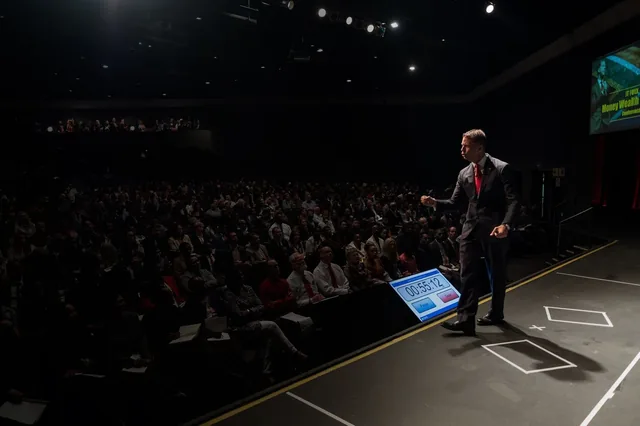 JT Foxx speaking on stage at a business event